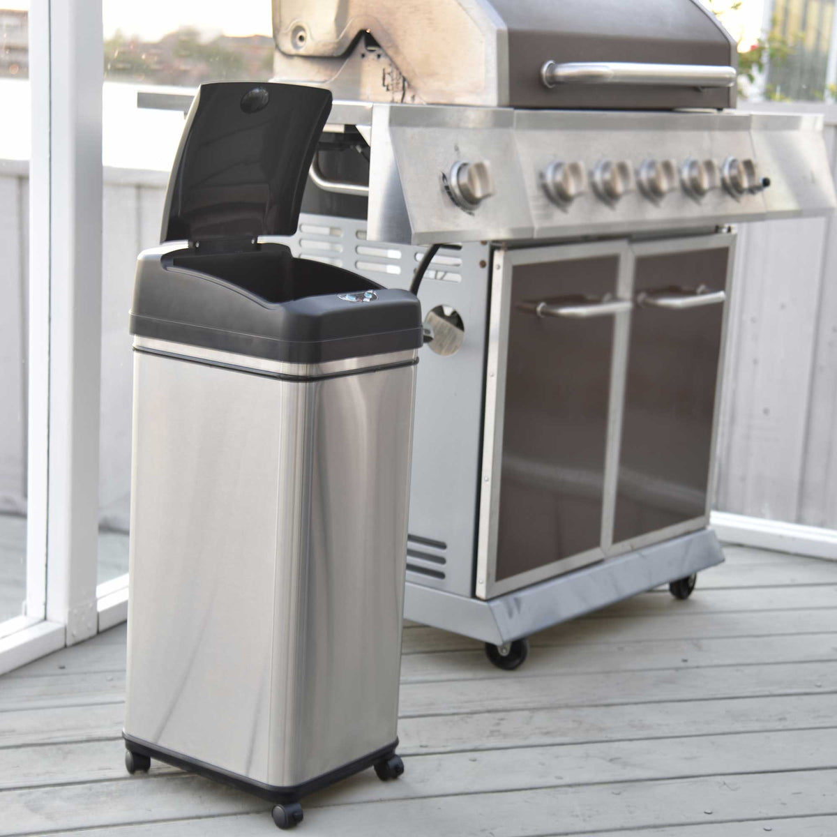 iTouchless Stainless Steel Trash Can with wheels in the backyard